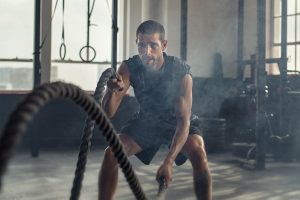 A guy using battle ropes